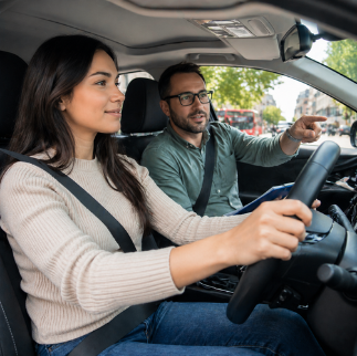 Driving instructor guiding a learner behind the wheel